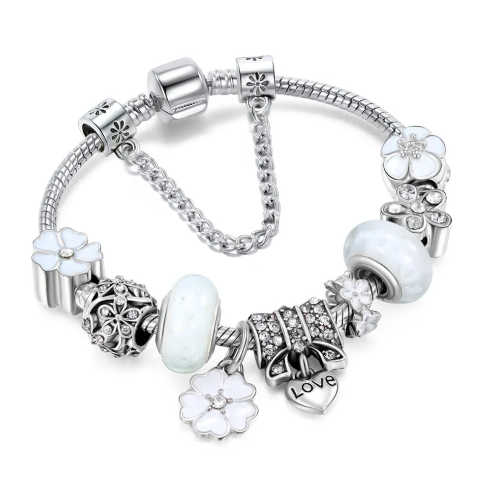 Elegant white charm bracelet with sterling silver floral beads, white glass charms, and a heart pendant engraved with 'Love' – perfect women's jewelry accessory and gift.